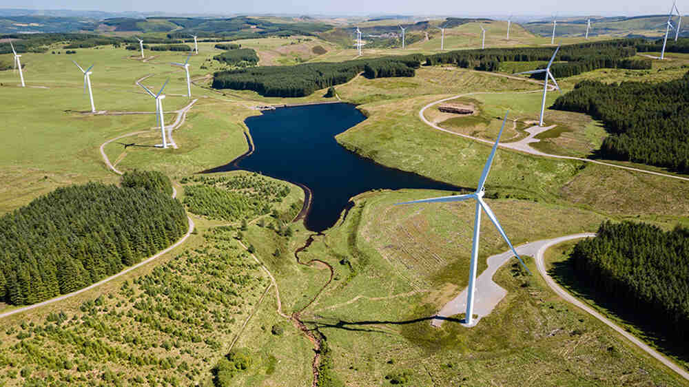 Onshore Wind Farm With Lake And Forest